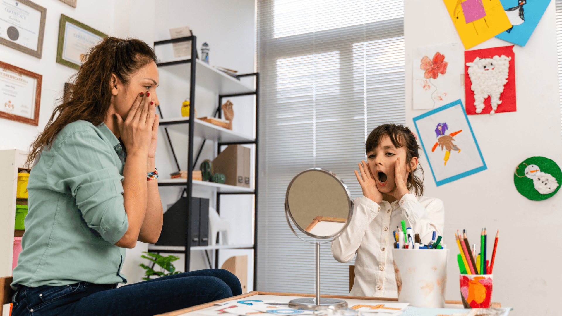 A child practising speech sounds in front of a mirror during a therapy session